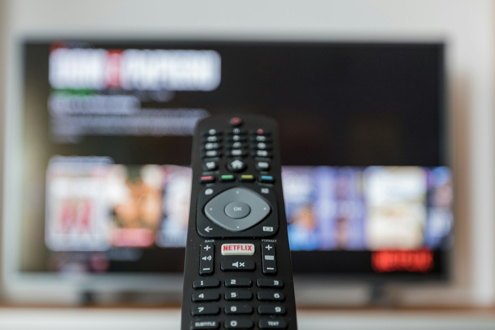 A remote control pointed at a television screen